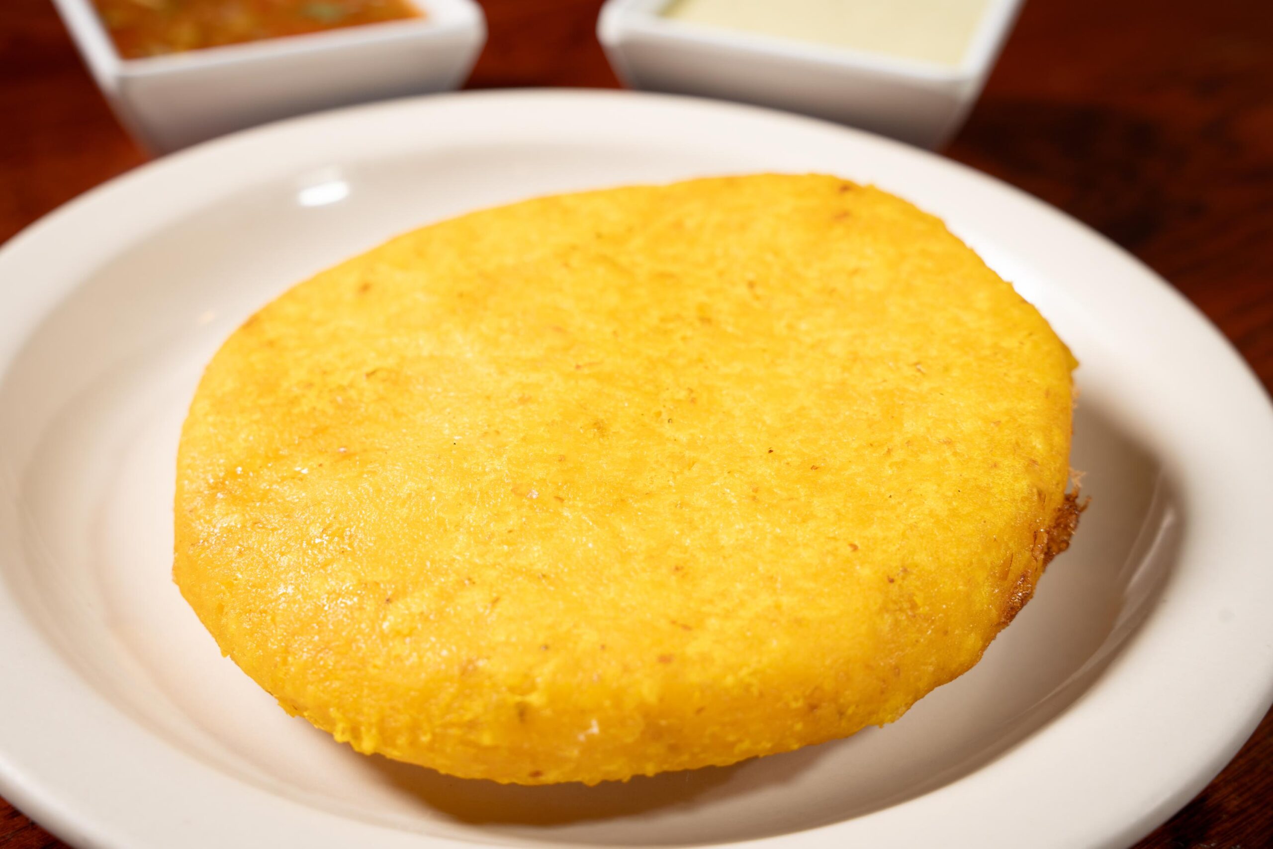 Deep-fried golden corn arepa stuffed with a whole fried egg at America’s Bakery and Restaurant in Davie, FL.