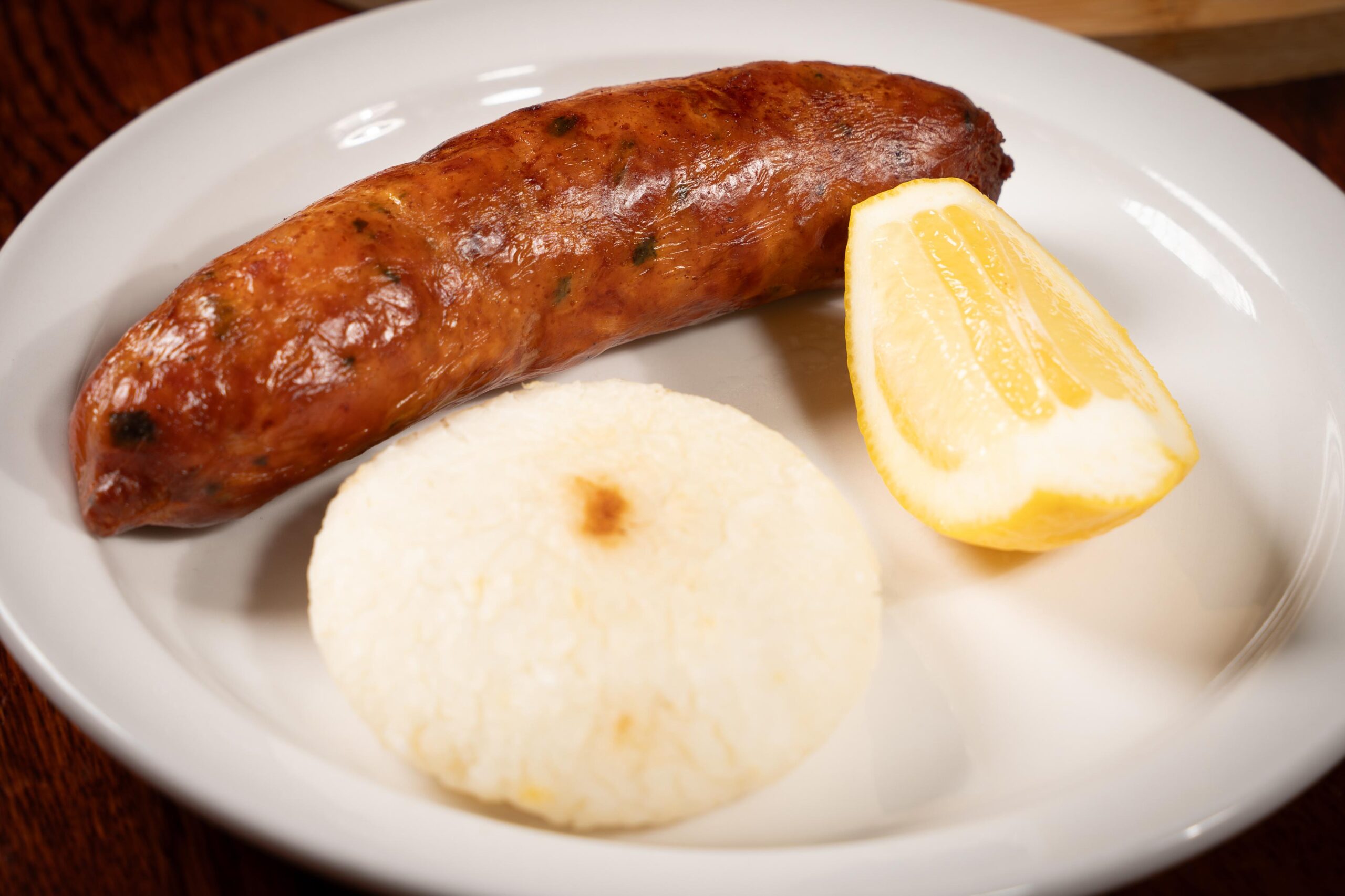 Traditional Colombian pork sausage (chorizo) served with a white corn arepa and salted potatoes in Davie, FL.