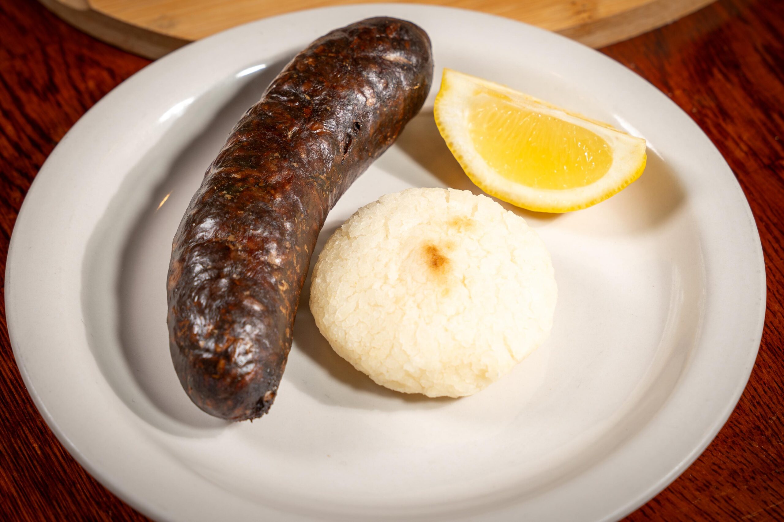 Authentic Colombian blood sausage (morcilla) served with a white corn arepita and salted potatoes in Davie, FL.