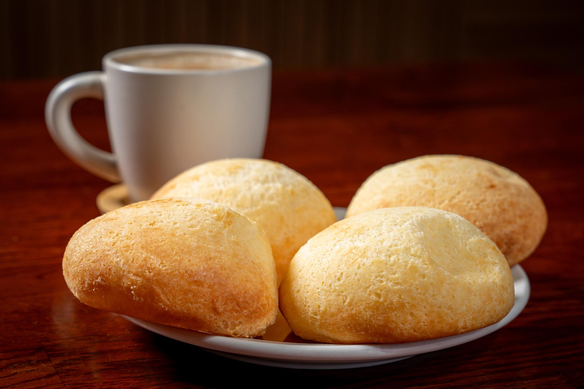 Warm, golden-brown Colombian Pandebono cheese bread rolls, naturally gluten-free, at a bakery in Davie, FL.