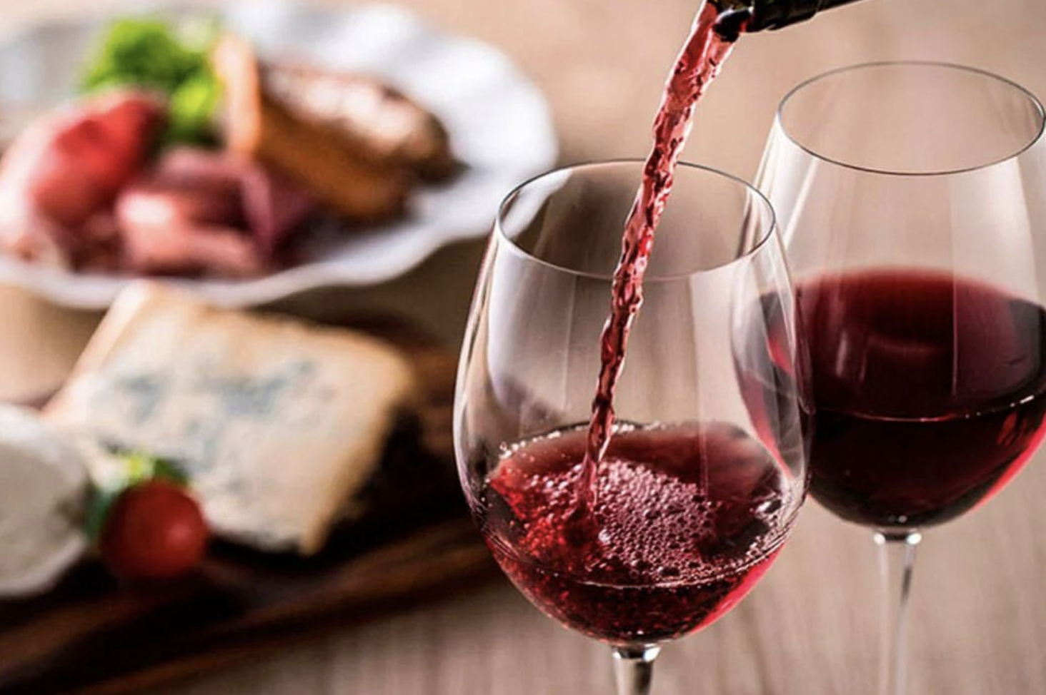 Copa de vino tinto servida en restaurante en Hollywood Florida acompañada de comida